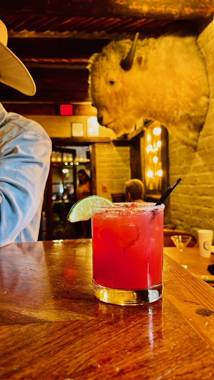 Bulk Prickly Pear Simple Syrup showcased in a vibrant cocktail, highlighting its rich color and refreshing appeal.
