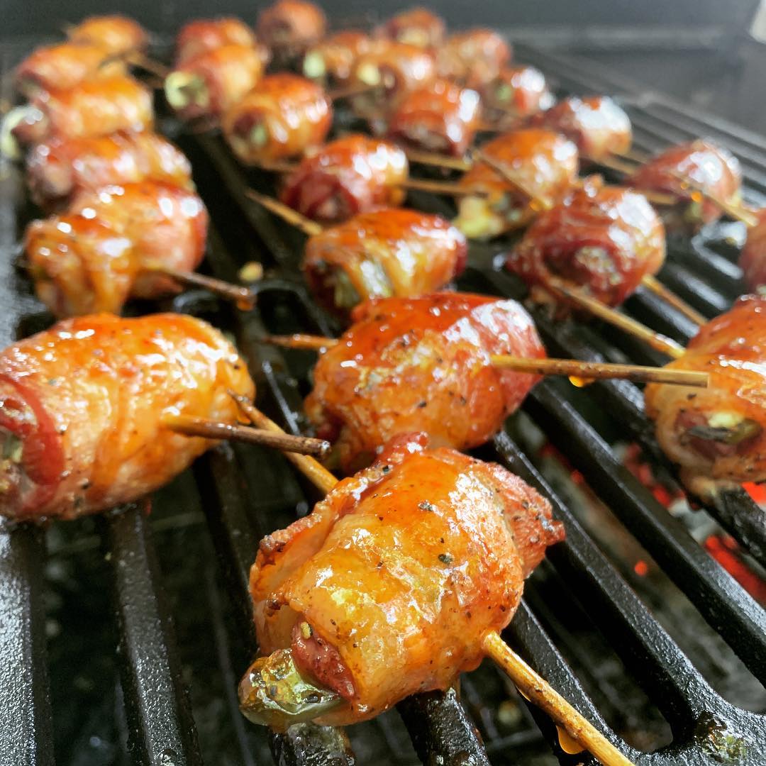 Grilled bacon-wrapped jalapeño poppers glazed with Brushfire Glaze, showcasing a smoky, savory finish on the grill.