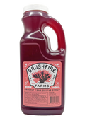 Bulk Prickly Pear Simple Syrup in a clear jug, featuring a vibrant pink color and Brushfire Farms branding.