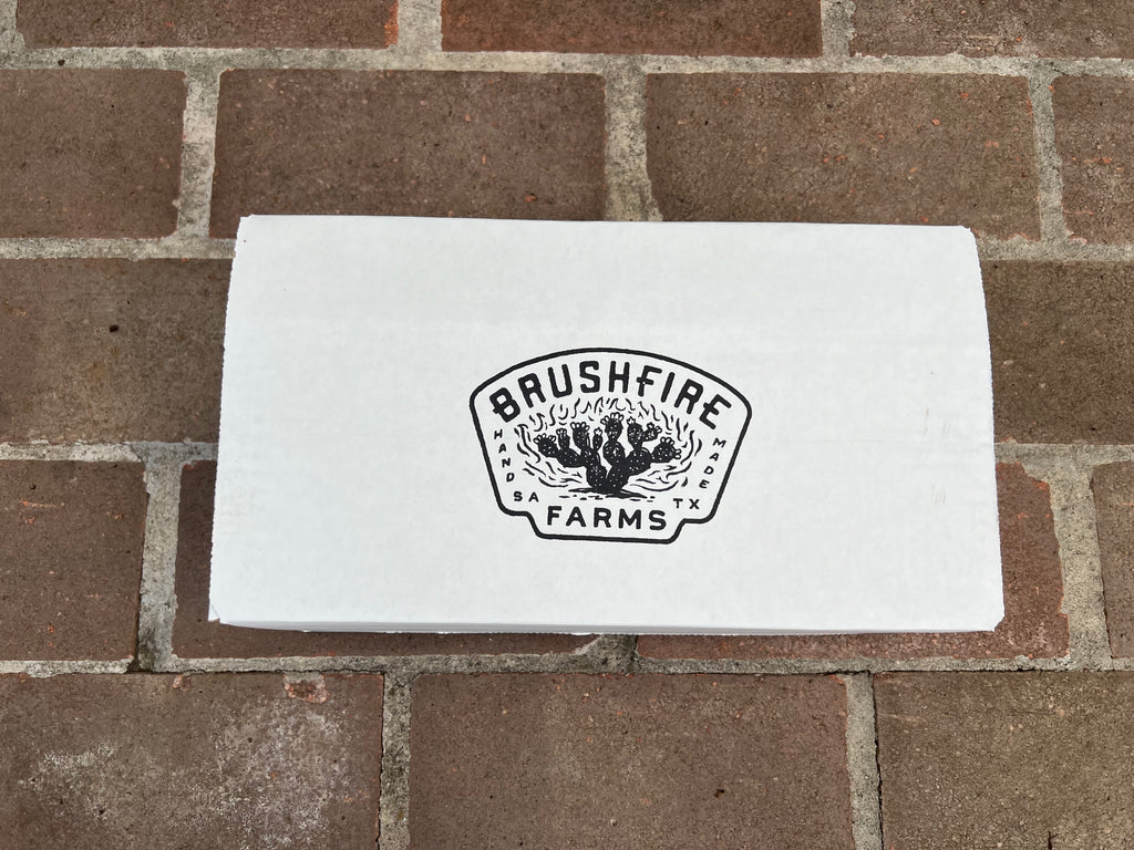 White box with Brushfire Farms logo on a brick surface, showcasing the Three Amigos product.
