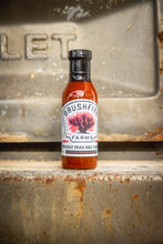 Load image into Gallery viewer, Bottle of Bushfire Farms prickly pear BBQ sauce on a rustic metal surface
