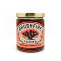 Jar of Brushfire Farms Original Pepper Jam featuring vibrant label design with cactus and flames, showcasing Texas flavor.